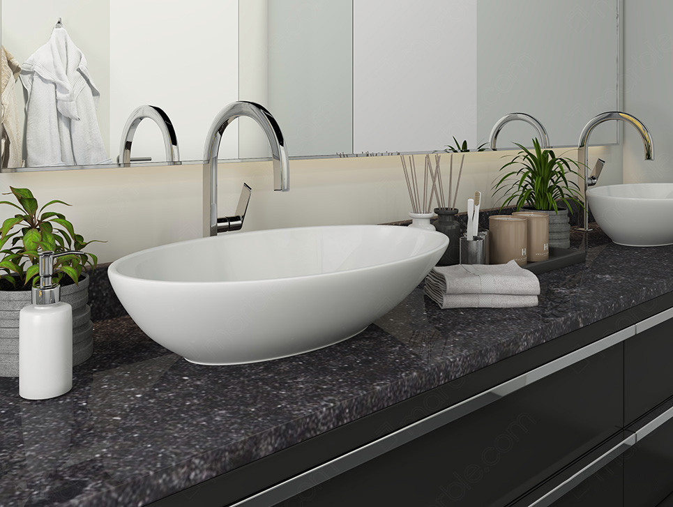 Bathroom has white washbasin with black quartz countertop